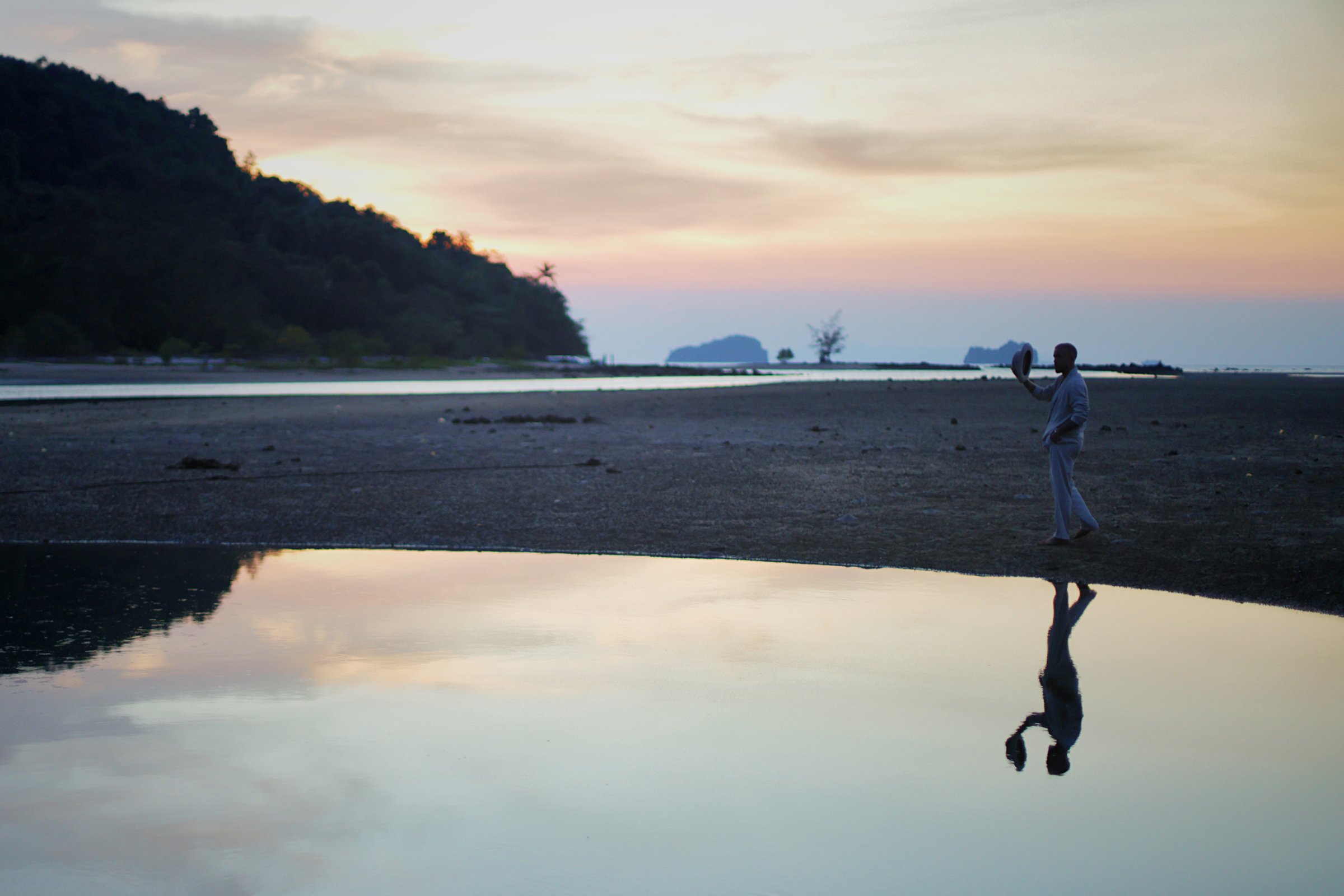 A man alone on the beach at dusk, where The Edge is held